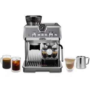 Silver DeLonghi espresso machine brewing two shots with a portafilter; two glass mugs of coffee on the left and a latte in a glass on the right; milk pitcher nearby