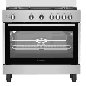 Stainless steel freestanding gas range with six burners, front control knobs, and a large glass oven door showing interior racks and fan. Brand Ariston appears on the oven door panel.