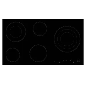 Black ceramic electric cooktop with five circular heating zones and touch controls in the bottom-right corner.