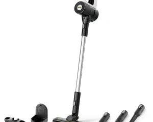 Cordless stick vacuum with a long wand and multiple cleaning attachments laid out on a white background.